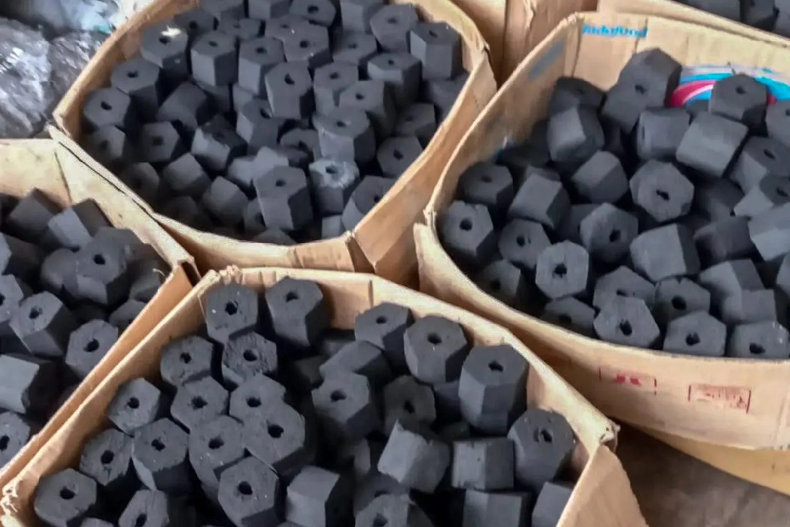 Hexagonal coconut shell charcoal briquettes packed in woven baskets