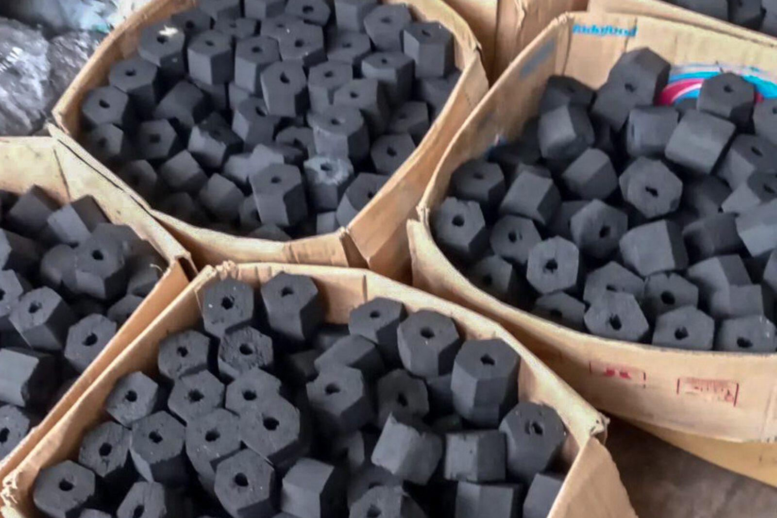 Hexagonal coconut shell charcoal briquettes packed in woven baskets